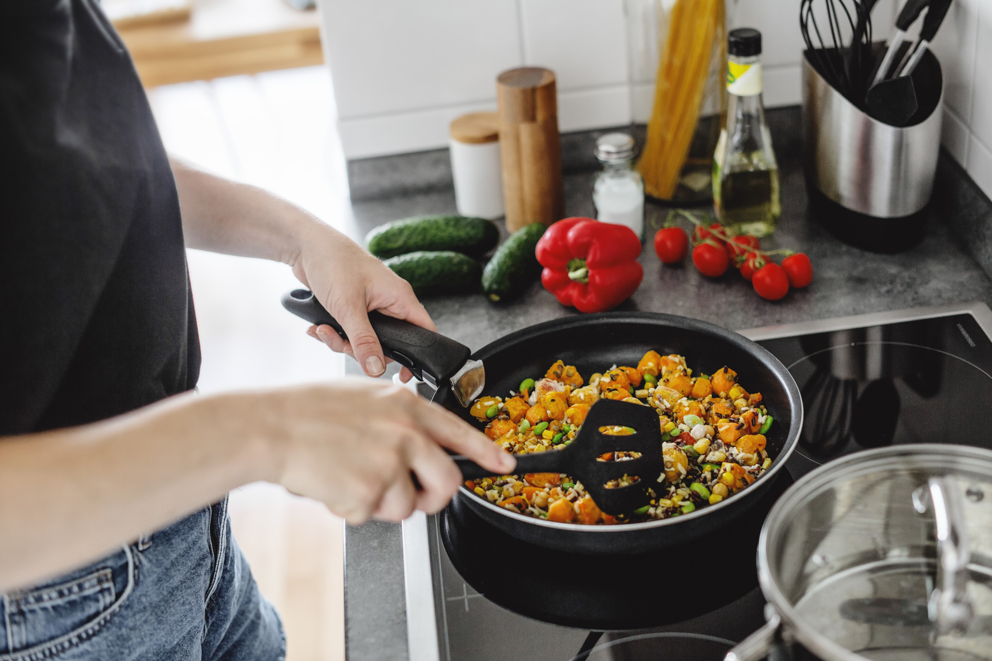 young-woman-cooking-fresh-vegetables-pan-home